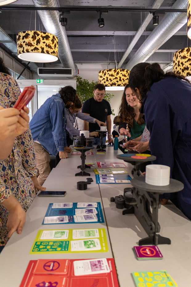 Etudiants hommes et femmes debout autour d'une table, jouent à un jeu de carte